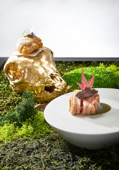 El sándwich de cochinillo ibérico, pecorino, yema de oca curada, sriracha casera, fiambre de cabeza de cochinillo, pimientas del mundo y pesto de trompetas (setas).