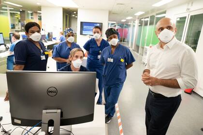 El secretario británico de Salud, Sajid Javid (derecha), se reúne con trabajadores de una unidad de cuidados intensivos para pacientes con Covid-19 durante una visita al Kings College Hospital de Londres (Stefan Rousseau/PA vía AP)