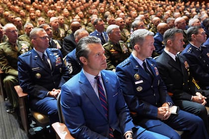 El secretario de Defensa Pete Hegseth (al centro), sentado junto al jefe del Estado Mayor Conjunto, general de la Fuerza Aérea Dan Caine (tercero desde la derecha), y altos mandos militares estadounidenses, escuchan el discurso del presidente Donald Trump en la Base del Cuerpo de Infantería de Marina de Quantico