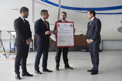 El secretario de Estado de Estados Unidos, Marco Rubio, a la derecha, escucha a Edwin F. Lopez, agregado del Departamento de Seguridad Nacional, segundo por la izquierda, junto al avión del gobierno venezolano que Rubio anunció estaba siento confiscado por Estados Unidos, durante una conferencia de prensa en el aeropuerto de La Isabela en Santo Domingo, República Dominicana, el 6 de febrero de 2025
