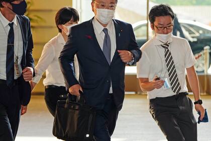 El secretario de Gabinete de Japón, Hirokazu Matsuno, al centro, llega a la oficina del primer ministro, el martes 4 de octubre de 2022, en Tokio. (Kyodo News via AP)