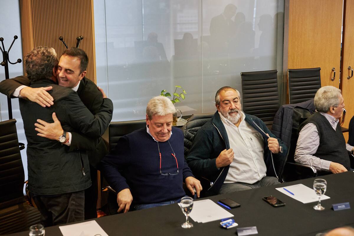 El secretario de Trabajo, Julio Cordero, abraza a Gerardo Martínez en el último encuentro de la CGT con el funcionario; también asistieron Abel Furlán, Héctor Daer y Carlos Acuña