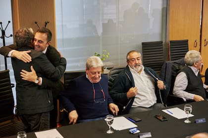 El secretario de Trabajo, Julio Cordero, abraza a Gerardo Martínez en el último encuentro de la CGT con el funcionario; también asistieron Abel Furlán, Héctor Daer y Carlos Acuña