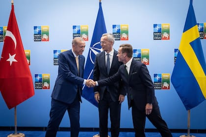 El secretario general de la OTAN Jens Stoltenberg, presencia el estrechamiento de manos entre el presidente turco Recep Tayyip Erdogan y el primer ministro sueco Ulf Kristersson, en la reunión de la OTAN en Vilna, Lituania