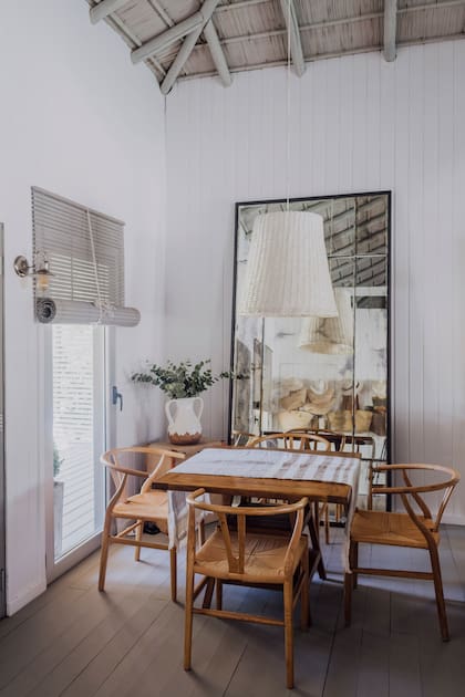 El sector de juegos tiene sillas Wishbone con asiento kraft y cortinas americanas engamadas con el cielo raso.