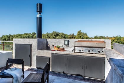 El sector de la parrilla se hizo en cemento y hierro. Las banquetas de guayubira son de AB Estudio.