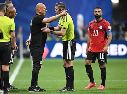 El seleccionador egipcio Hossam Hassan reclama ante el árbitro francés Francois Letexier, ante la mirada del capitán Mohamed Salah; el DT alentó la polémica al calificar que se trató de "partido amañado"