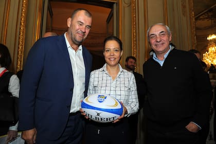 El seleccionador Michael Cheika y su antecesor Marcelo Loffreda, que condujo a los Pumas hacia el tercer puesto de Francia 2007, sonríen junto a la embajadora en Buenos Aires, Claudia Scherer-Effosse.
