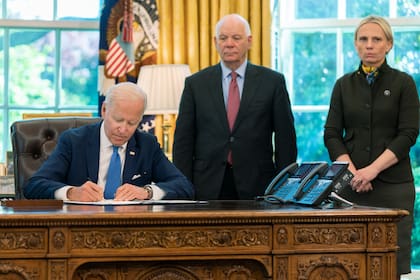 El senador demócrata Ben Cardin, en el centro, junto al presidente Joe Biden y la representante republicana Victoria Spart