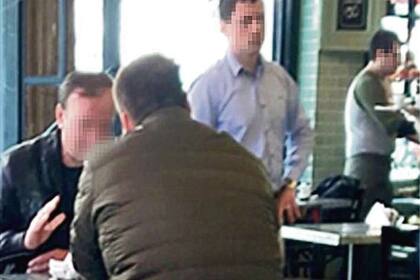 El Señor K (de negro), en un bar junto al policía Blizniouk, en su último viaje a Buenos Aires