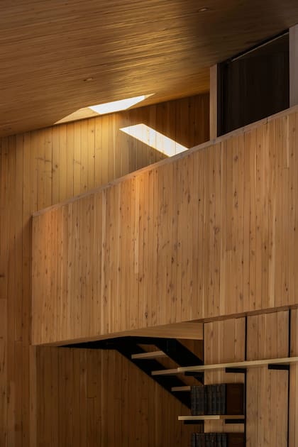 El sentido de las tablas de madera potencia la verticalidad de la doble altura.