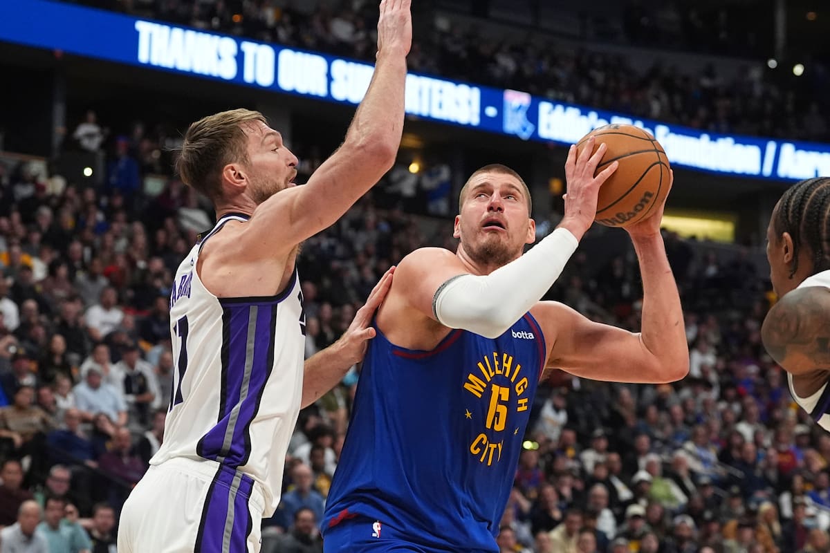 El serbio Nikola Jokic, pívot de los Nuggets de Denver, salta para encestar frente al lituano Domantas Sabonis, de los Kings de Sacramento