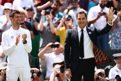 El serbio Novak Djokovic aplaude al suizo Roger Federer, en una ceremonia en el último Wimbledon, en el All England Tennis Club