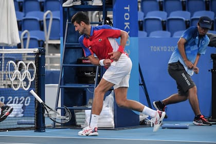 El serbio Novak Djokovic rompe su raqueta durante su partido de tenis individual masculino de los Juegos Olímpicos de Tokio 2020 por la medalla de bronce contra el español Pablo Carreño Busta.