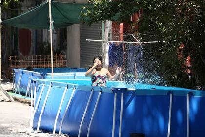 El Servicio Meteorológico Nacional emitió una alerta naranja por las altas temperaturas este viernes 14 en CABA (En foto: piletas de lona en la calle Pedro de Mendoza, La Boca.)