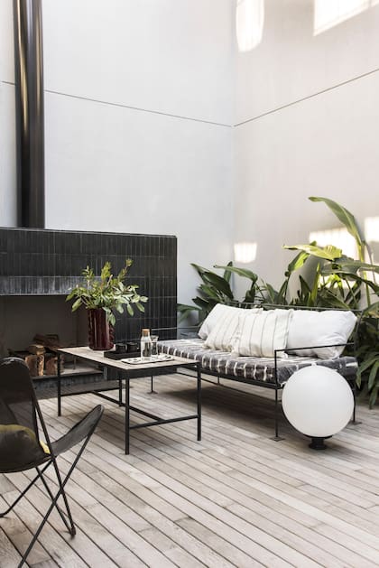 El sillón exterior tiene una colchoneta forrada en género pintado a mano (Blanco Concepto) y almohadones de lino (The Linen Store). Florero cerámico (Good Luck Casa).