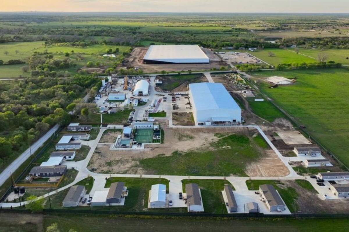 El sitio fotografiado en 2023, con las instalaciones de SpaceX en la parte superior, The Boring Company a la izquierda y el edificio que alberga negocios locales en el centro.