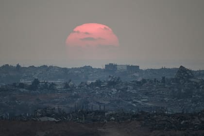 El sol se pone detrás de edificios fueron destruidos durante las operaciones terrestres y aéreas israelíes en el norte de la Franja de Gaza, visto desde el sur de Israel