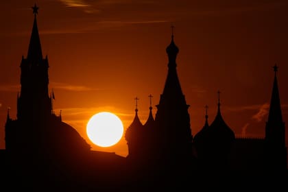 El sol se pone detrás del Kremlin y la Catedral de San Basilio, en Moscú