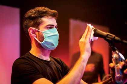 El stage de Kevin Johansen sanitiza uno de los micrófonos que se van a usar durante el recital