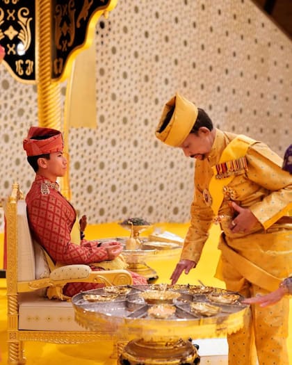 El sultán Muda Hassanal Bolkiah junto a su hijo, el príncipe Abdul Mateen, durante el rito del empolvado.