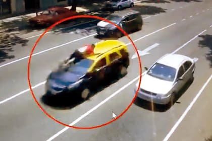 El taxista va tomado del techo de su auto mientras los delincuentes huyen