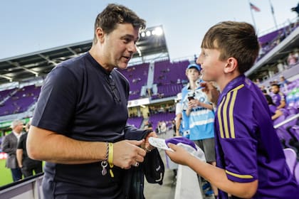 El técnico argentino de Estados Unidos, Mauricio Pochettino, conversa con Dylan McMahon, un aficionado de 10 años, previo al partido entre Orlando City y Charlotte FC en los playoffs de la MLS, el sábado 9 de noviembre de 2024, en Orlando, Florida. (AP Foto/Kevin Kolczynski)