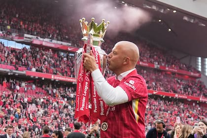 El técnico Arne Slot besa el trofeo de la Premier League durante la celebración al final de la última fecha, el domingo 25 de mayo de 2025, en el estadio Anfield. (AP Foto/Jon Super)