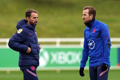 El técnico de Inglaterra Gareth Southgate conversa con el delantero Harry Kane (derecha) durante una sesión de entrenamiento en el St. George'Park, en Burton-upon-Trent, en Inglaterra, el martes 9 de noviembre de 2021, previo al partido contra Albania y San Marino por las eliminatorias a la Copa Mundial 2022. (Nick Potts/PA vía AP)