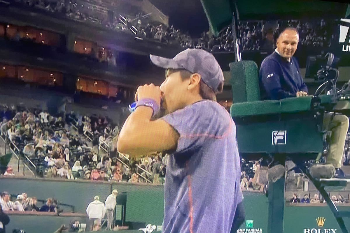 El tenista japonés Yosuke Watanuki tomando una gaseosa durante su partido de Indian Wells ante Frances Tiafoe; el umpire Mohamed Lahyani lo observa con sorpresa