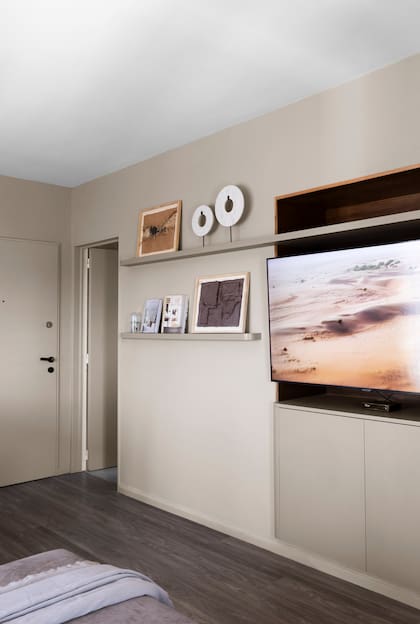 El tono 'Perfect Greige' (Sherwin Williams) se eligió específicamente buscando imitar el de la melamina 'Gris Tapir' (Fablac) de las puertas de guardado bajo la TV. Objetos deco (Casa María Paula).