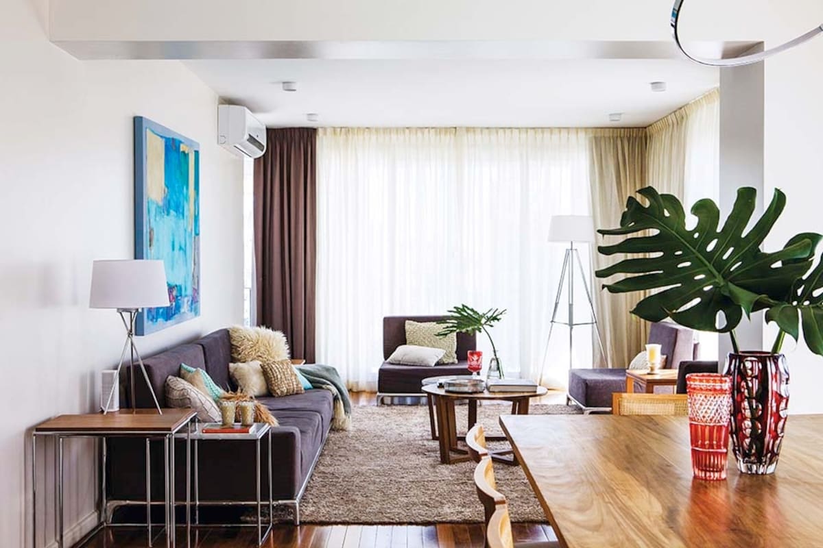 El toque verde en el living lo dan hojas esculturales en delicados floreros