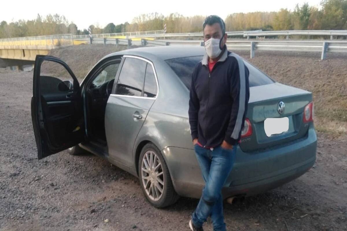 El trabajador petrolero posa para la foto junto a su auto