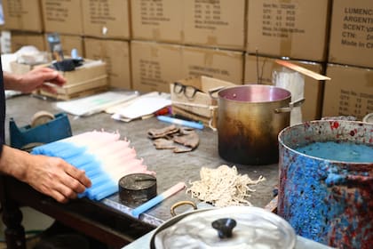 El trabajo artesanal completa distintas etapas de la producción, con baños de cera coloreada que permiten obtener las tonalidades asociadas a cada advocación