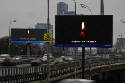 El tráfico circula por la autopista junto a un cartel en que dice "Lloramos al 03.22.2024" en Moscú, Rusia, el sábado 23 de marzo de 2024, tras un ataque el viernes reivindicado por el grupo Estado Islámico. (AP Foto/Alexander Zemlianichenko)
