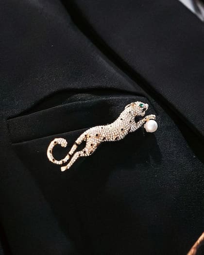 El traje sumaba un elegante prendedor dorado con forma de leopardo
