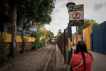 El tren avanza rumbo al Riachuelo tras pasar junto a la Bombonera: una turista china retrata la escena
