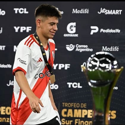 El Trofeo de Campeones en primer plano; detrás, Claudio Echeverri luce la medalla
