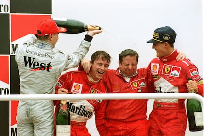 El último podio: Mika Hakkinen baña con champagne a Eddie Irvine, Jean Todt y Michael Schumacher, ganador del Gran Premio de la Argentina 1998; pasaron 25 años de aquella última función del Gran Circo en el autódromo Oscar y Juan Gálvez