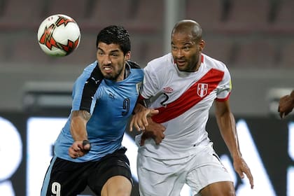 El uruguayo Luis Suárez (izquierda) lucha por el balón con el peruano Alberto Rodríguez durante un partido de clasificación para la Copa Mundial de 2018 en Lima, Perú, el martes 28 de marzo de 2017. (Foto AP/Martín Mejía)