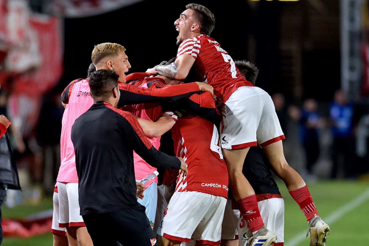 El uruguayo Mauro Méndez en la cima del festejo de los jugadores de Estudiantes, luego del agónico gol de Heredia