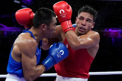 El venezolano Jesús Cova, a la derecha, en su combate de octavos de final en los 63 kilogramos ante el tailandés Bunjong Sinsiri, el lunes 29 de julio de 2024, en Villepinte, Francia. (AP Foto/Ariana Cubillos)
