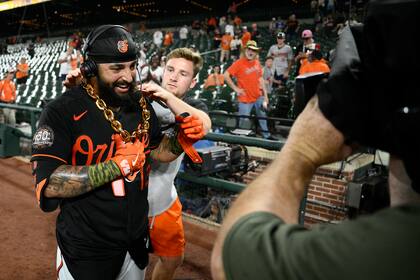 El venezolano Rougned Odor, de los Orioles de Baltimore, recibe la "cadena del jonrón", tras el encuentro ante los Rays de Tampa Bay, el viernes 20 de mayo de 2022 (AP Foto/Nick Wass)