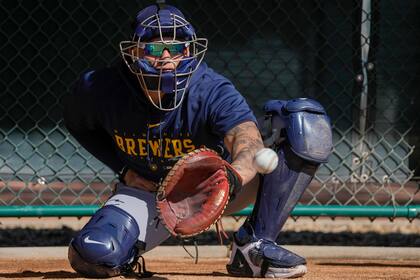El venezolano William Contreras, de los Cerveceros de Milwaukee, atrapa un lanzamiento en una práctica de pretemporada en Phoenix, el jueves 16 de febrero de 2023 (AP Foto/Morry Gash)