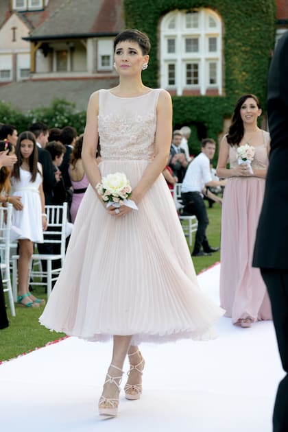 El vestido de líneas net de Flor, by Marisa Campanella, hecho en organza de seda natural plisada con espalda descubierta. ¿Los zapatos? Charlotte Olympia.