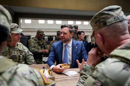 El vicepresidente de Estados Unidos, JD Vance, come una hamburguesa con miembros de la Guardia Nacional en Union Station, en Washington, el 20 de agosto de 2025. (Alexander Drago/Pool vía AP)
