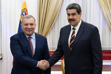 El viceprimer ministro ruso Yuri Borisov y el presidente venezolano Nicolás Maduro estrechan las manos en el palacio presidencial de Caracas, el miércoles 16 de febrero de 2022. (AP Foto/Matias Delacroix)