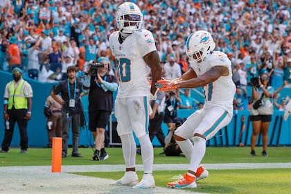 El wide receiver Tyreek Hill (10) de los Dolphins coloca sus manos como si estuviera esposado durante el partido contra los Jaguars de Jacksonville, el domingo 8 de septiembre de 2024, en Miami Gardens, Florida. (Al Díaz/Miami Herald vía AP)