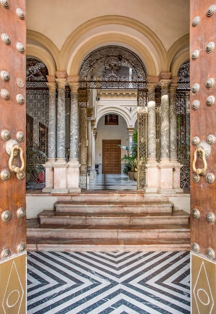 El zaguán marcaba el paso entre el mundo exterior y la intimidad del palacio. Su escalinata de mármol rojo, sus columnas, arcadas y delicada herrería conservan la monumentalidad original.