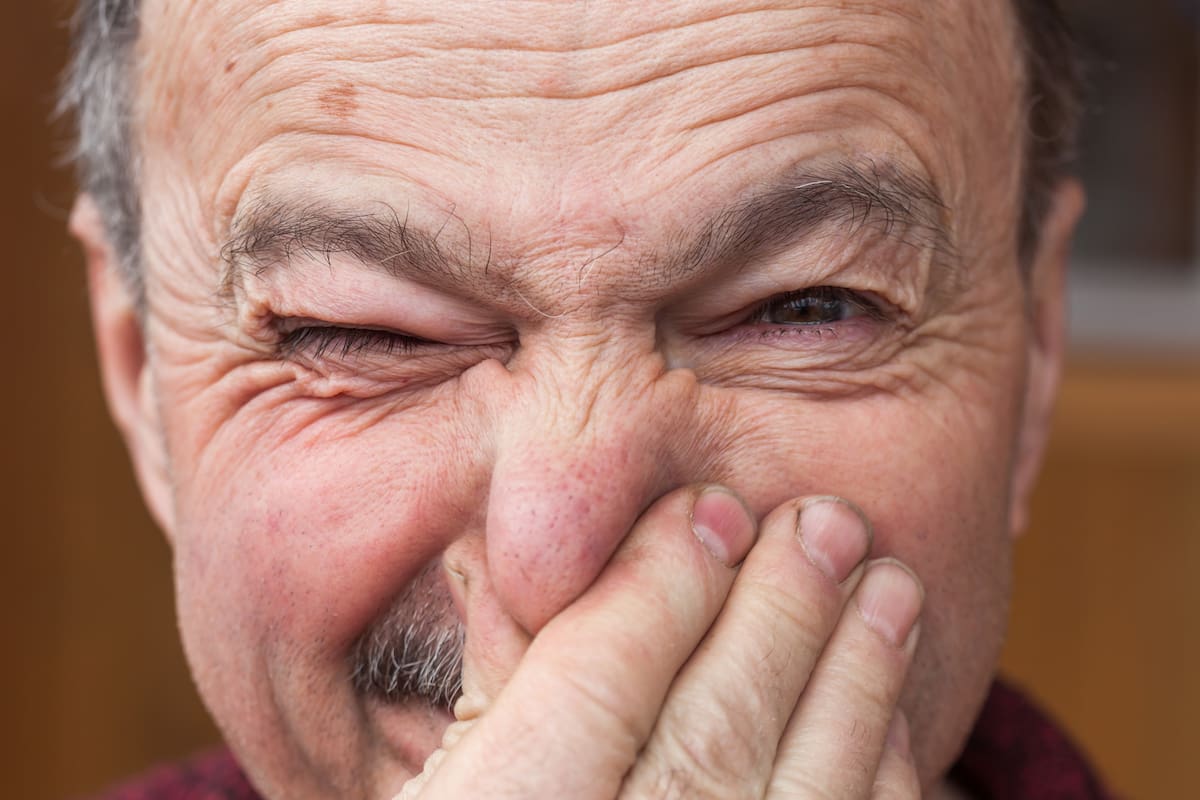 Elderly man hands nose plugs because of unpleasant smell